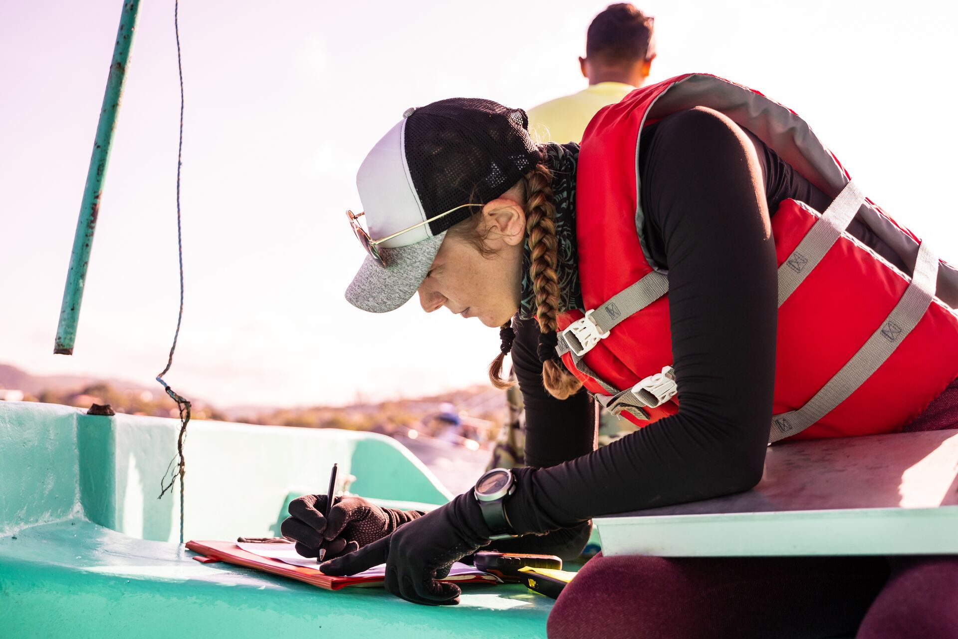 A woman wears a life jacket and writes a list, boat safety equipment checklist concept. 