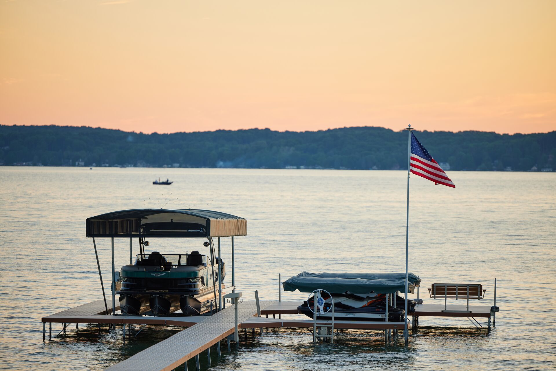 A boat at a dock flying the U.S. flag on a lake. 